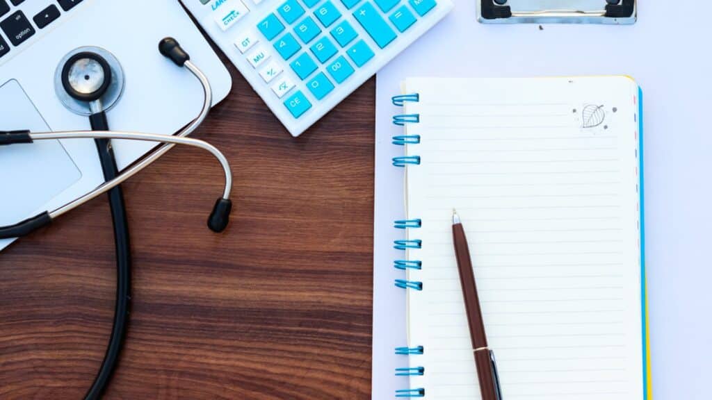 Calculator, stethoscope and a notepad on a desk, illustrating what a breast lift costs in the UK and in Turkey